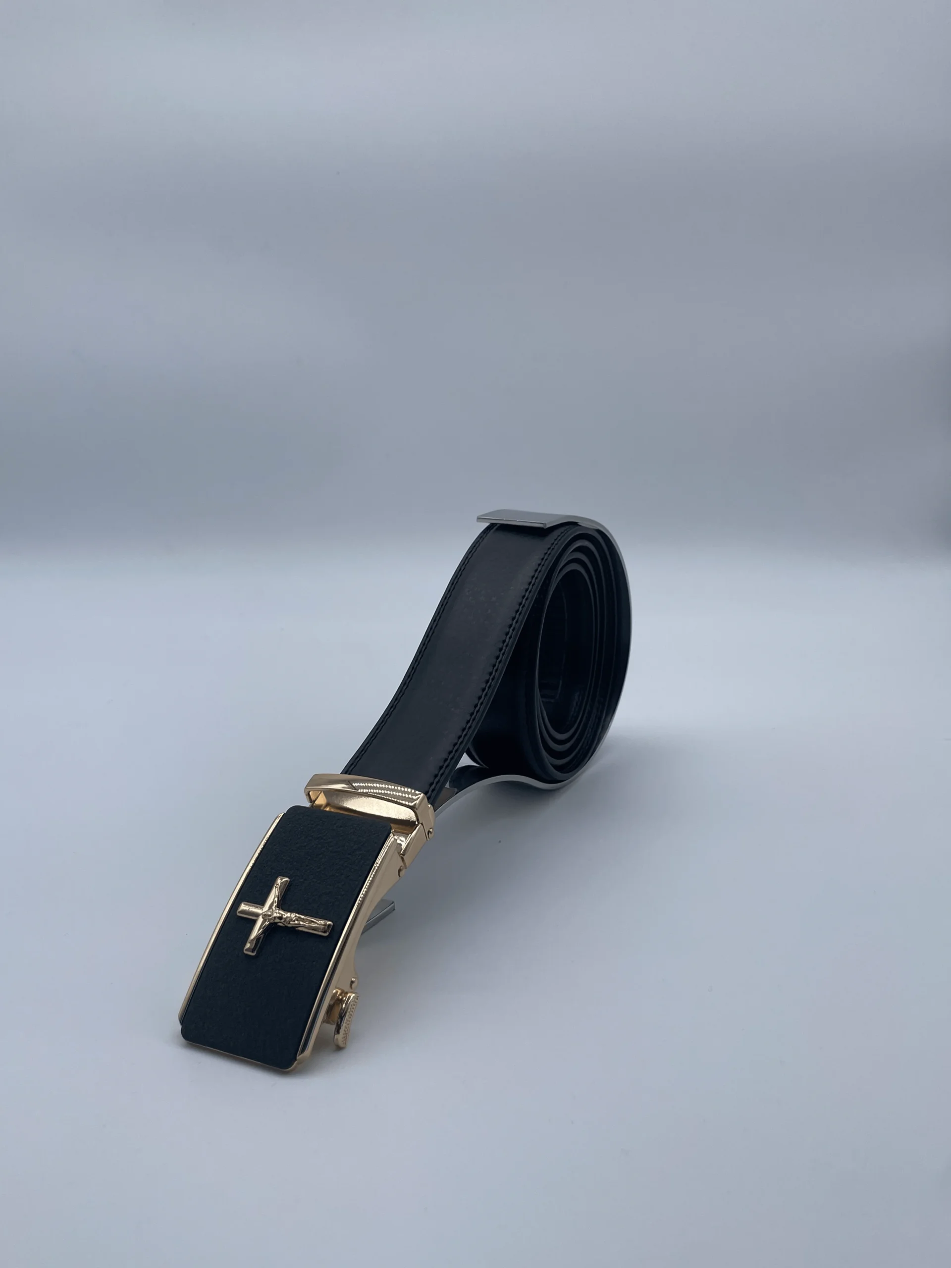 Ceinture pour homme modèle Jesus, en cuir noir, boucle automatique dorée avec croix en relief. Élégante et inspirante.